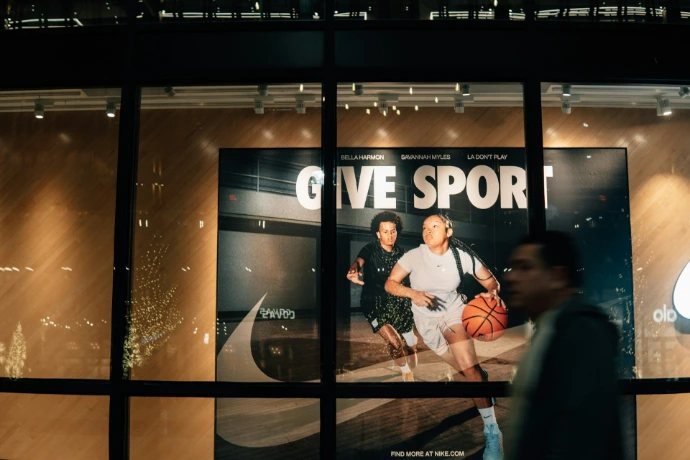 People walking past a nike store at night